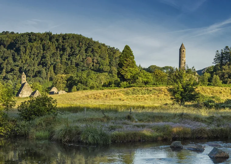 Glendalough’s round tower and monastic ruins reflected in the quiet valley landscape